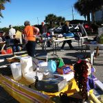 Shoppers browsing tables at a community yard sale