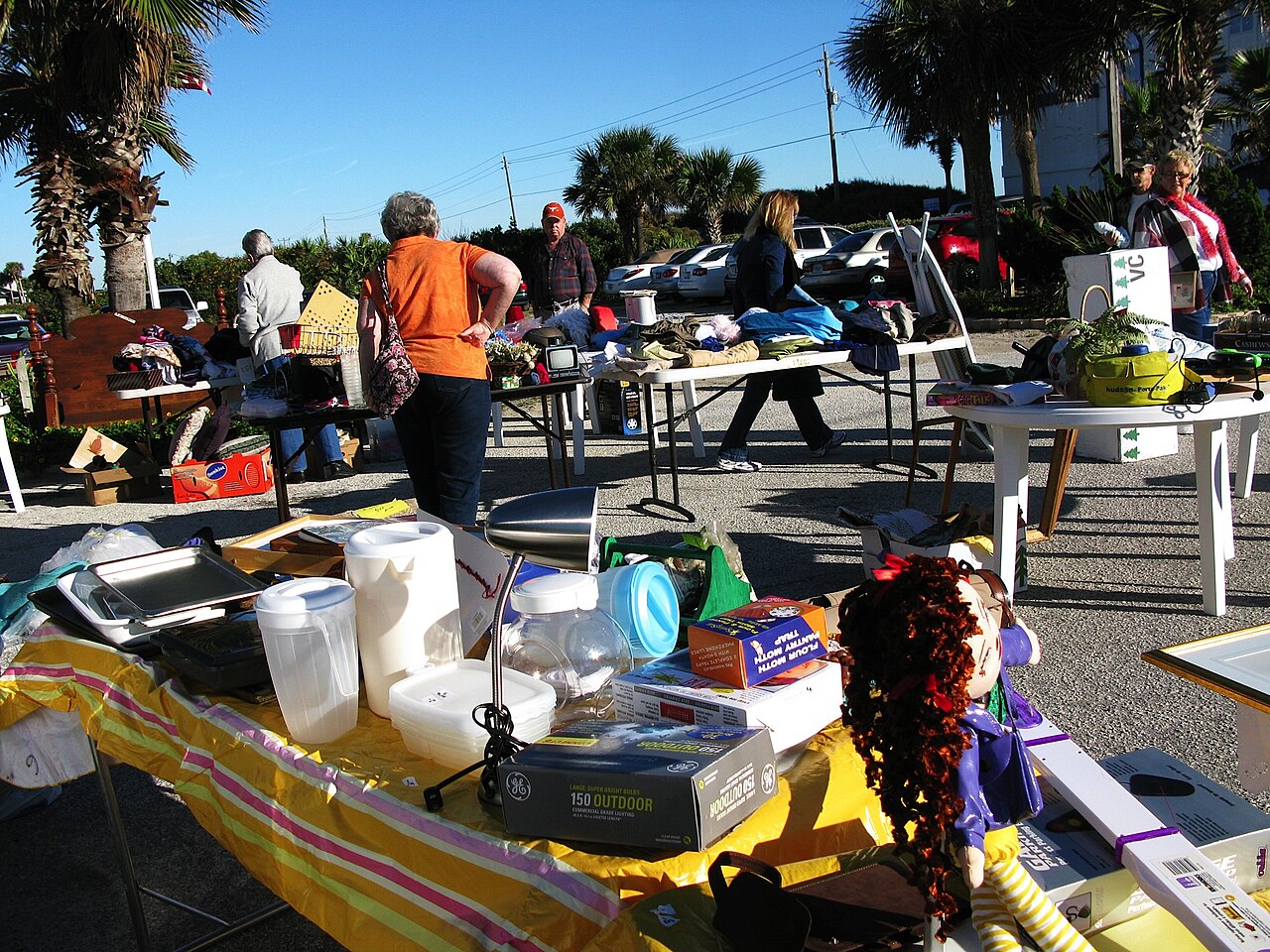 Shoppers browsing tables at a community yard sale
