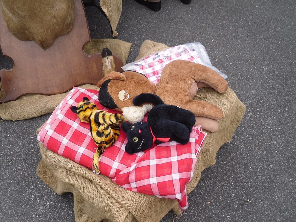 Old stuffed animals for sale on a vendor table